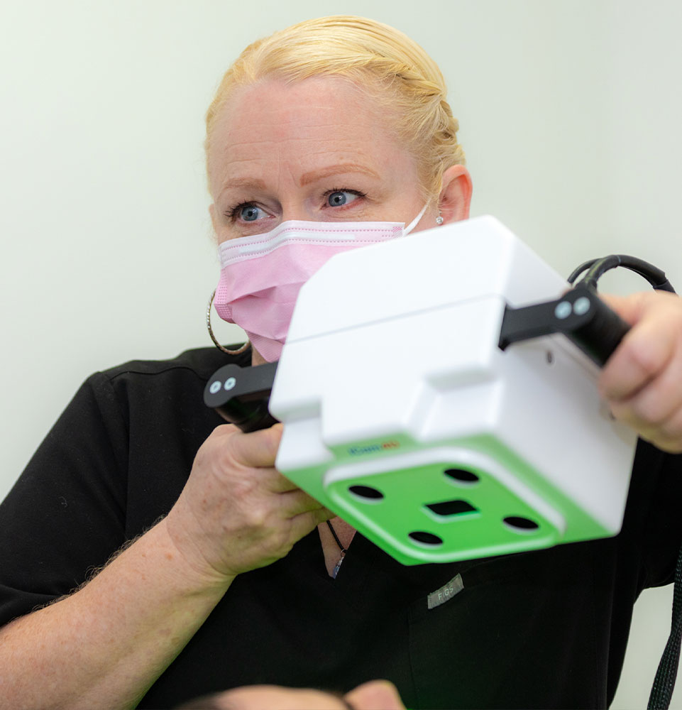 staff member using dental device for dental treatment