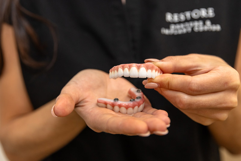 Dr. Alyssa Mencini Holding An All-on-4 Dental Implant Prosthesis Made From Zirconia