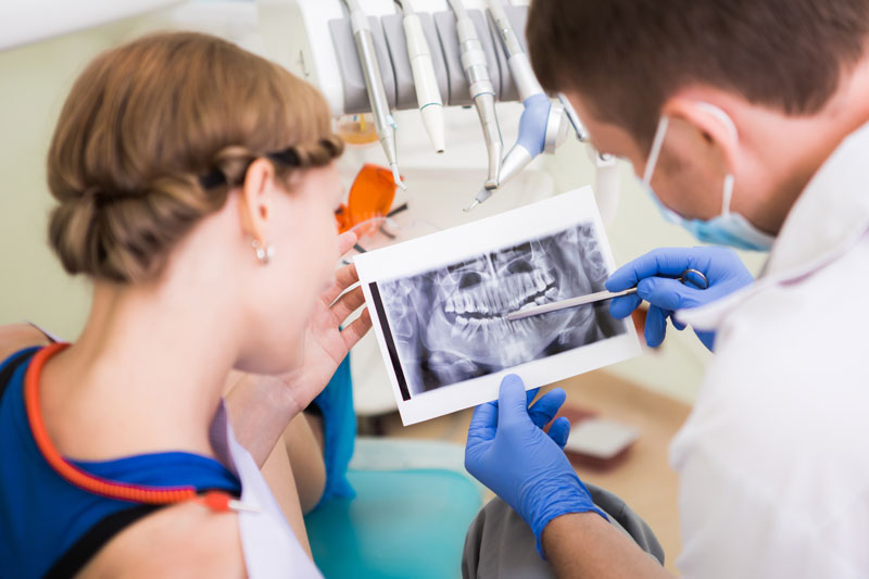 a doctor showing a patient an x-ray of her teeth